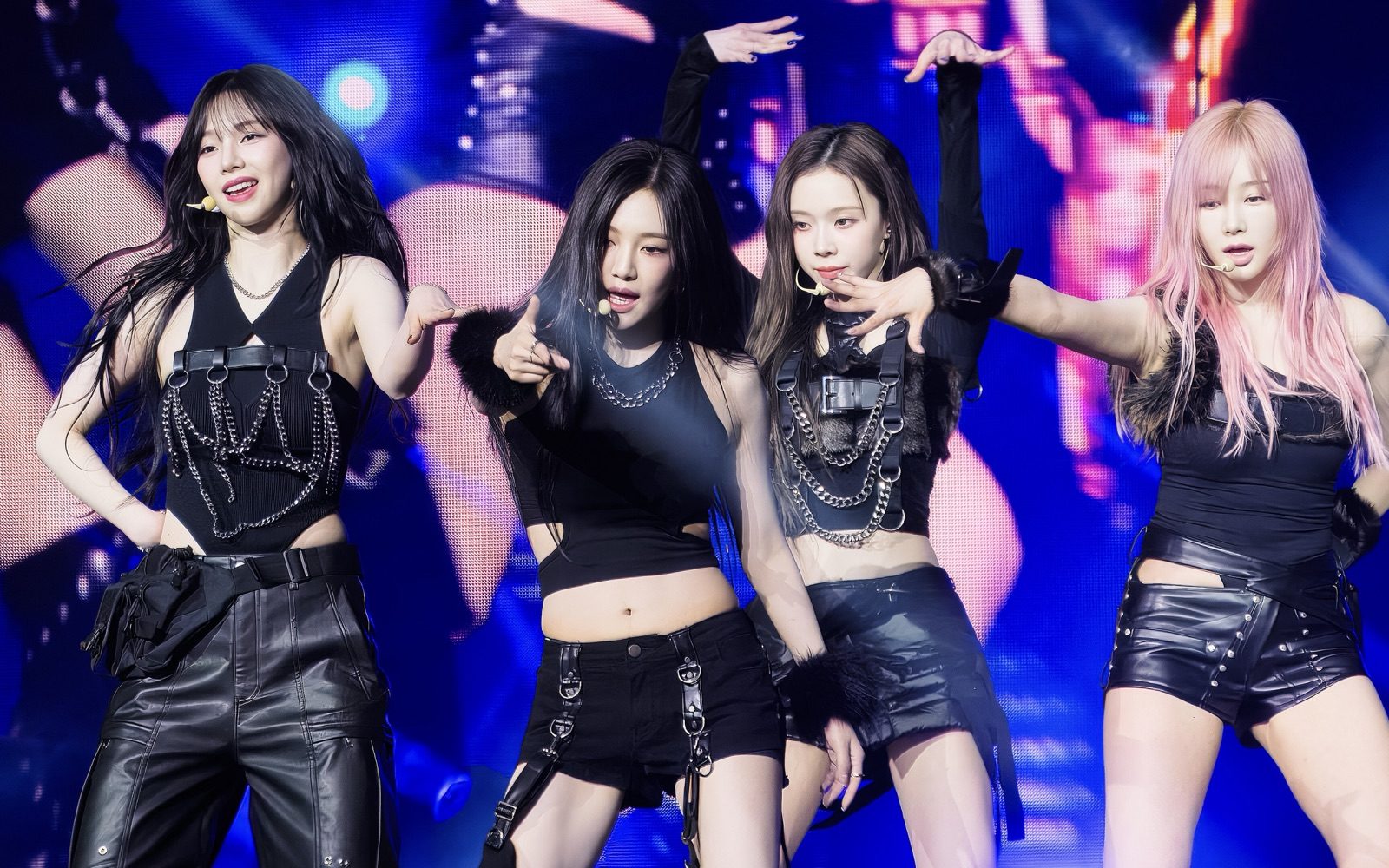 A desktop wallpaper made by AudioPaper while aespa's Next Level plays: the four members of aespa on stage in black, lit in blue and pink, filling the screen.